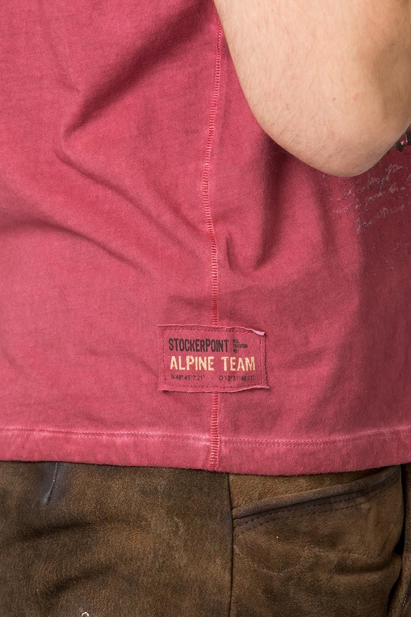 Ein Stockerpoint-Alpine-Team-T-Shirt in Rot mit Lederhose.