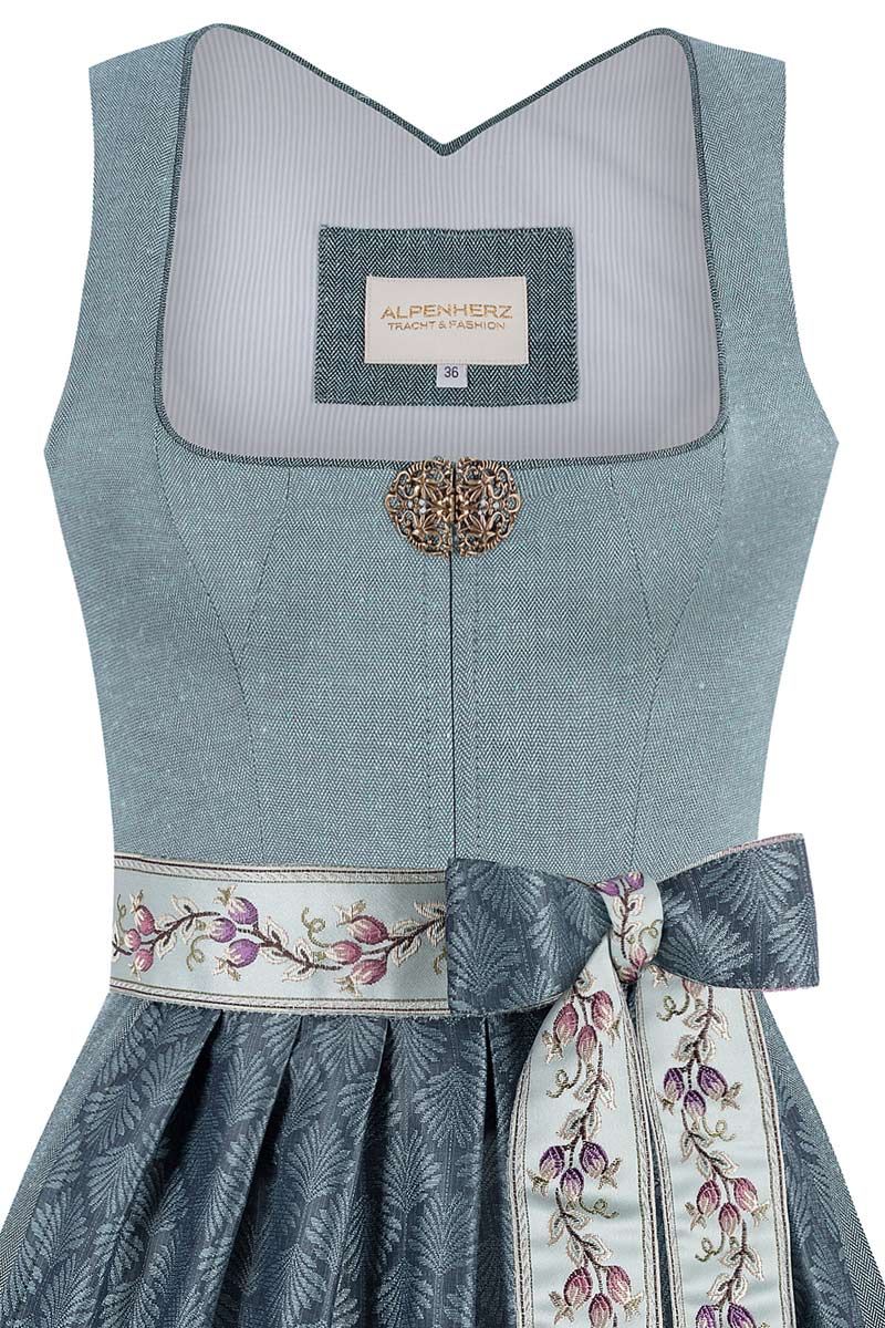 Elegantes blaues Dirndl von Alpenherz mit floraler Schleife und feinem Muster.