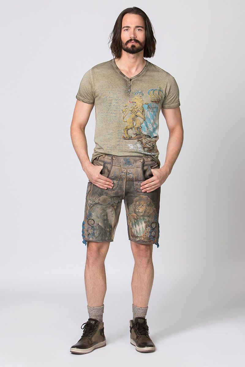 Ein Mann trägt moderne Lederhosen mit bayerischem Löwenmotiv von MOSER Trachten.