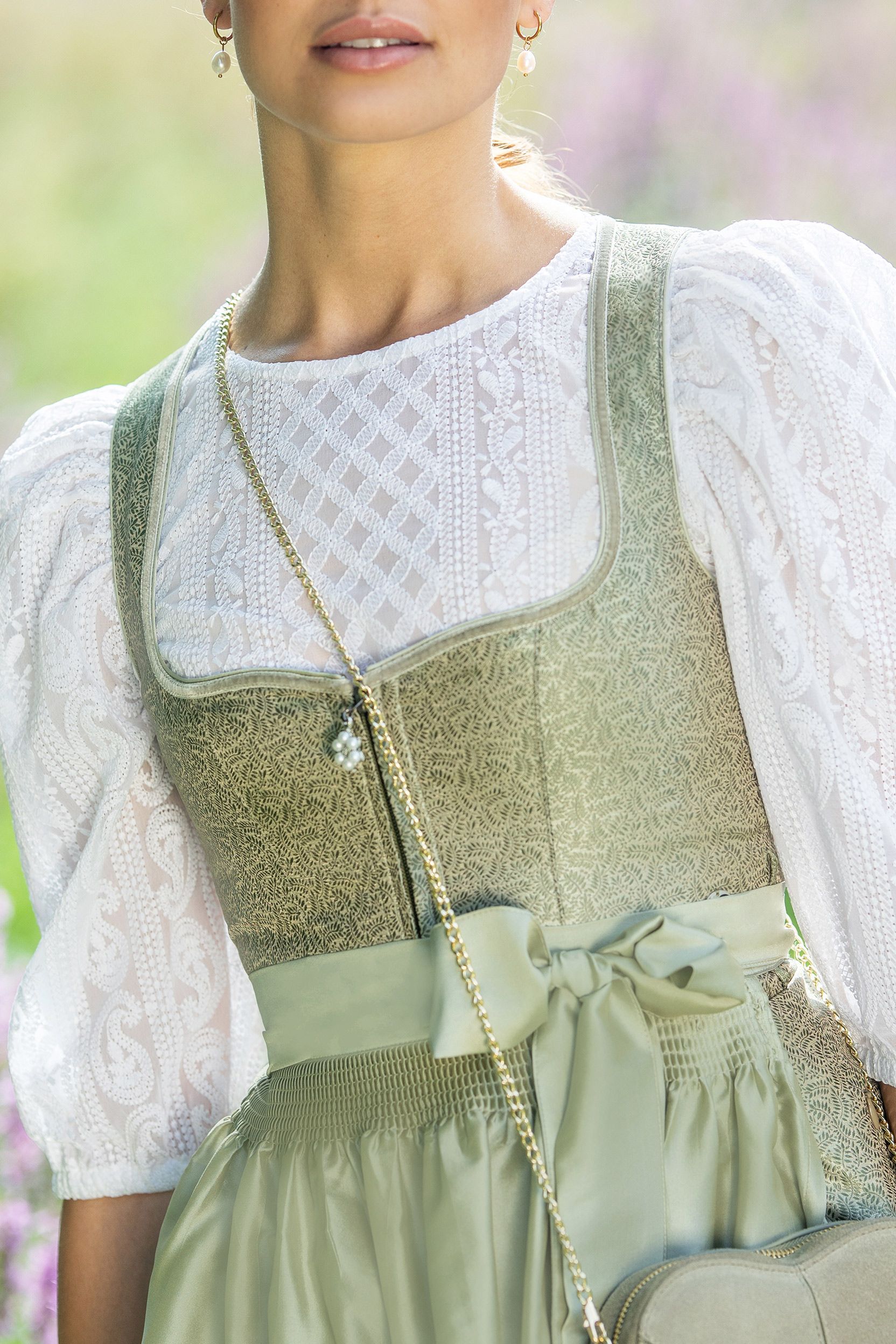 Ein grünes Dirndl mit Spitzenbluse von MOSER Trachten präsentiert traditionellen Stil.
