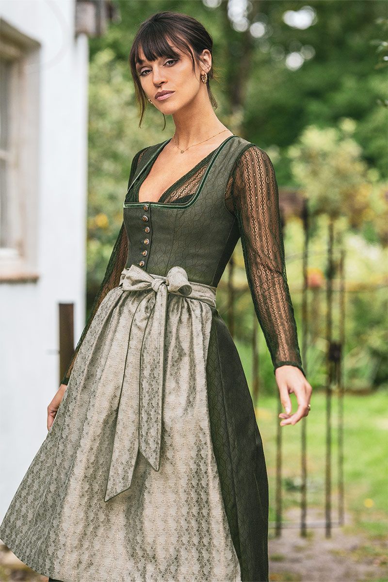 Elegantes Dirndl von MOSER Trachten in Grün mit Spitzenbluse und traditioneller Schürze.