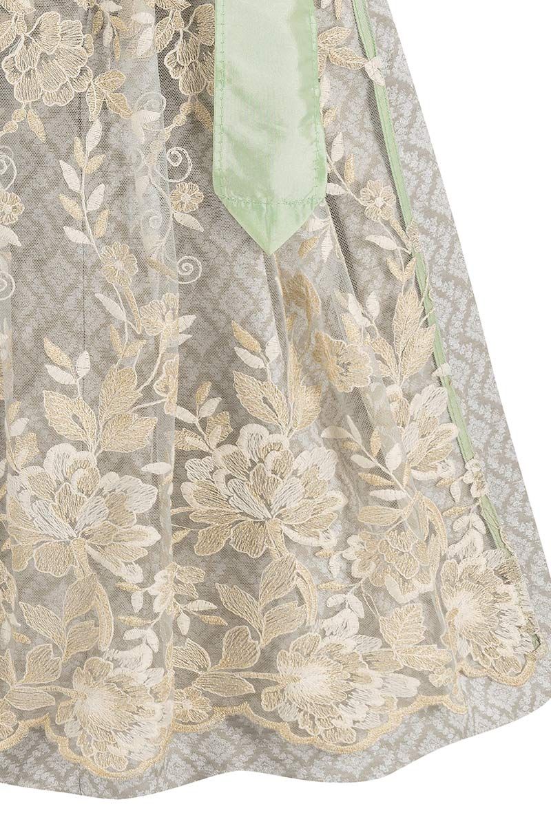 Spitzenapplikation auf eleganter Trachten-Schürze mit floralen Stickereien in Creme und Grün.