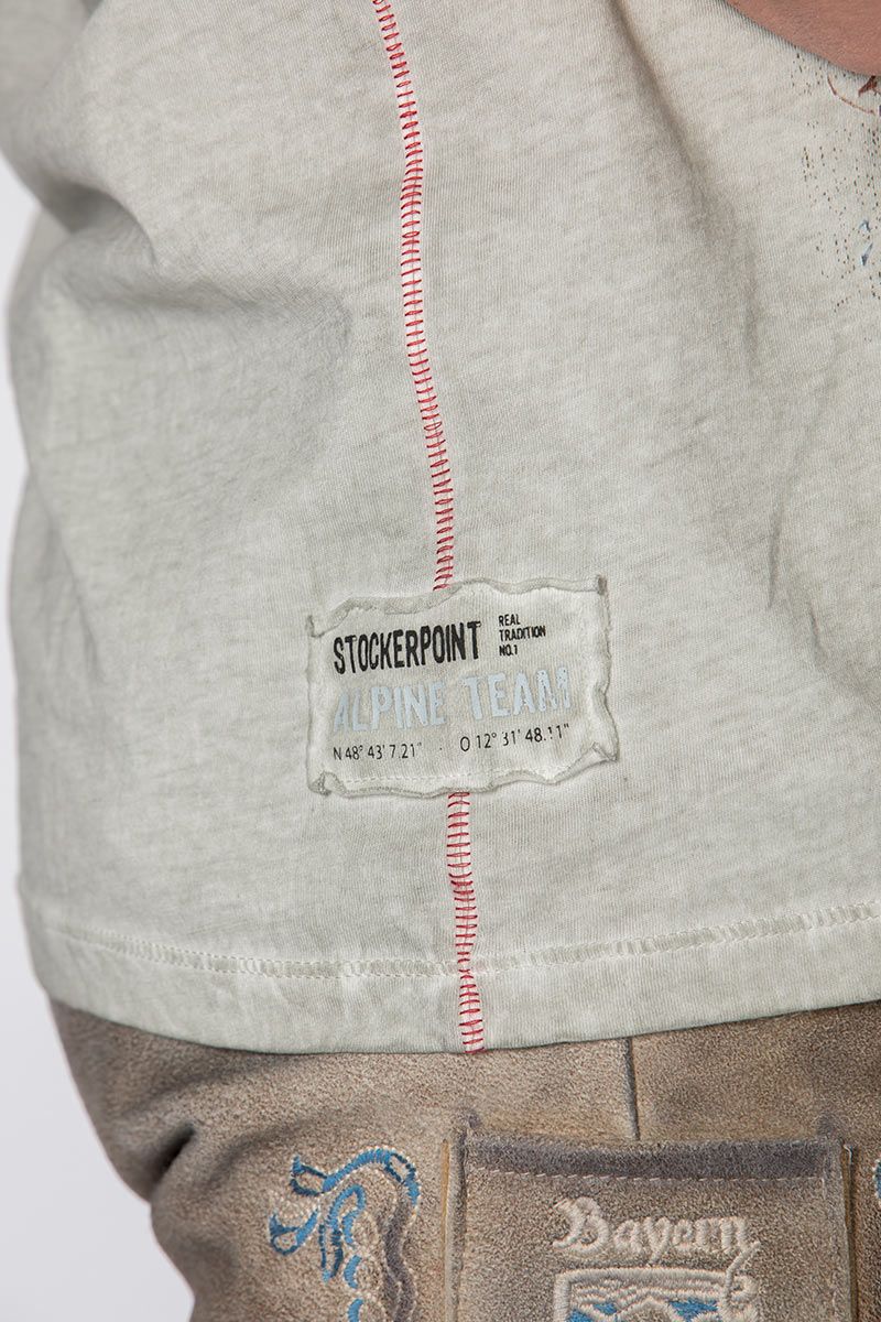 Graues T-Shirt von Stockerpoint mit roten Nähten und Alpine Team Aufnäher.